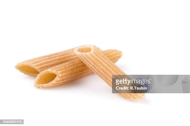 wholemeal pasta penne as close-up shot isolated on white background - whole wheat penne pasta stock pictures, royalty-free photos & images
