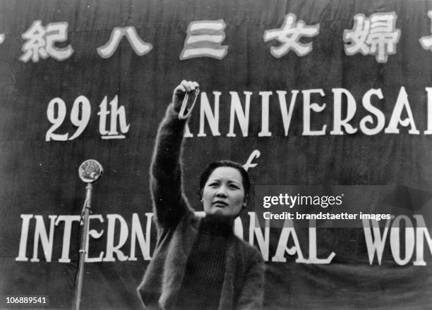 Madame Chiang Kai-shek holds a speech in front of 10.000 Chinese women at the International Women's Day. In her up-raised hand, she holds a silver...