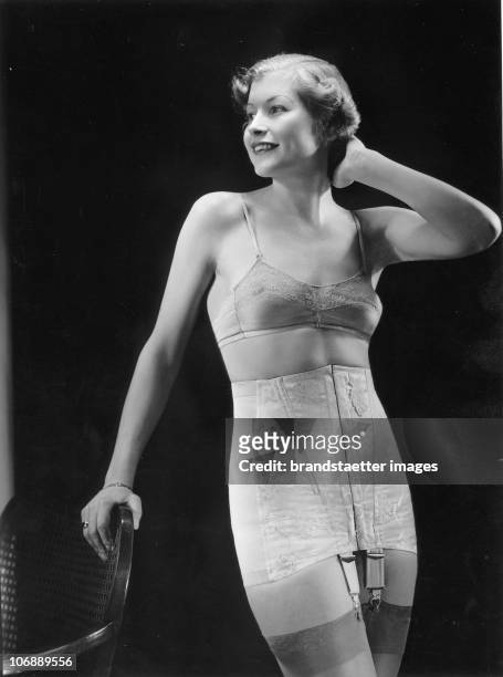 Advertising picture of a woman wearing a jacquard sateen girdle with elastic inserts on the side. Photograph. Around 1930