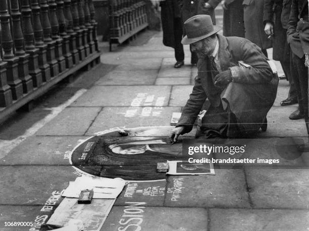 Streetartist is painting Jan Vermeer´s "The girl with the pearlearring" on the pavement. Photograph. Around 1930.