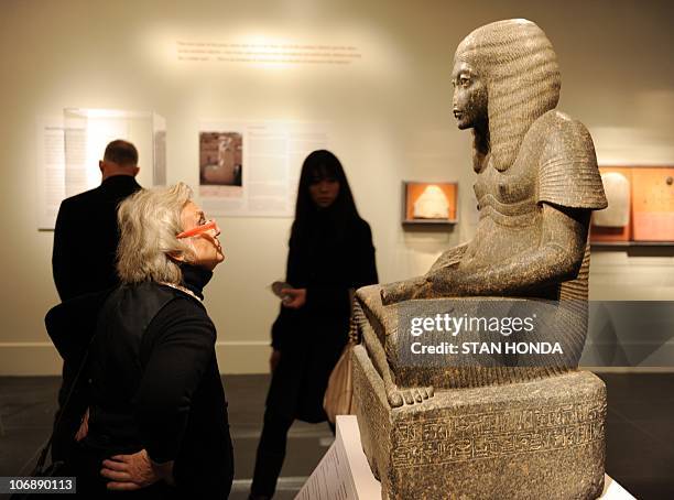 Woman views a stone statue "Haremhab as a Scribe", New Kingdom, Dynasty 18, reign of Tutankhamun or Aya, ca. 1328�1316 B.C., on display Novermber 15,...