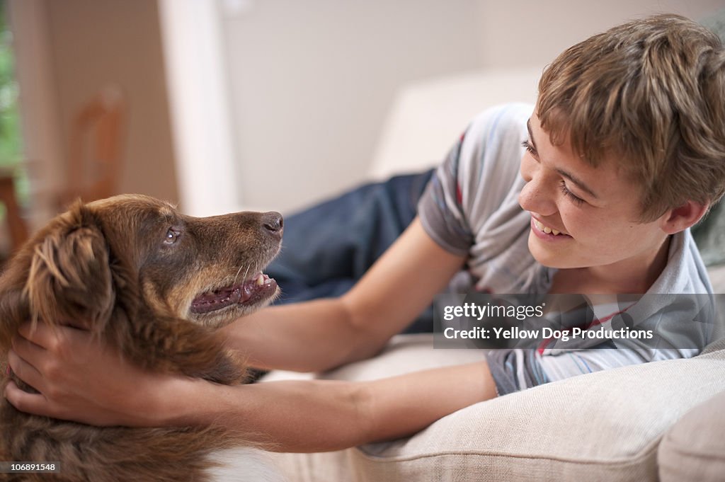 Teenage boy hugging his pet dog