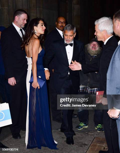 Amal Clooney and George Clooney greet Radioman outside Cipriani 42nd Street on December 5, 2018 in New York City.