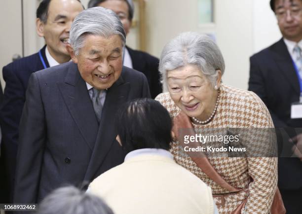 Japanese Emperor Akihito and Empress Michiko talk with a resident of a welfare facility set up for people with learning disabilities in Tokyo's...