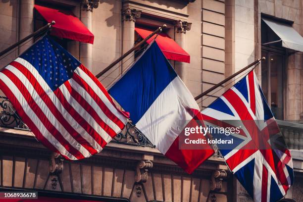 american, france and uk flags waving on fifth avenue - france v united states stockfoto's en -beelden