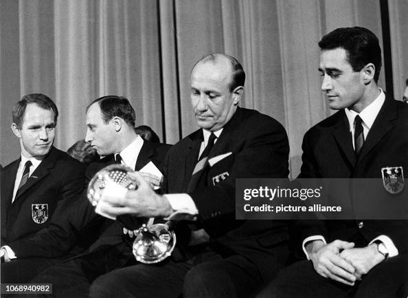 National coach Helmut Schön examines the cup which he and the German ...