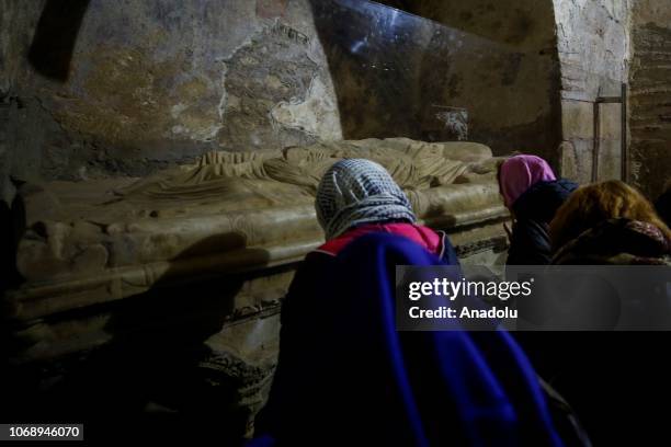 People pray near the burial place of Saint Nicholas during a mass which marks the death anniversary of Saint Nicholas, also known as Santa Claus at...