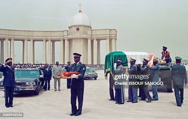 Photo taken on February 7, 1994 shows Ivorian military officers carrying the flag drapped coffin of Felix Houphouet-Boigny, the first president of...