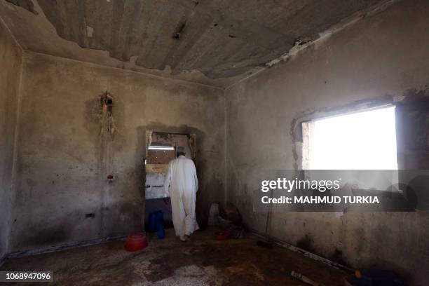 Libyan farmer Mahmoud Abou al-Habel checks his burnt house in Tawergha, 260 km east of the Libyan capital Tripoli, on November 9, 2018. Displaced...