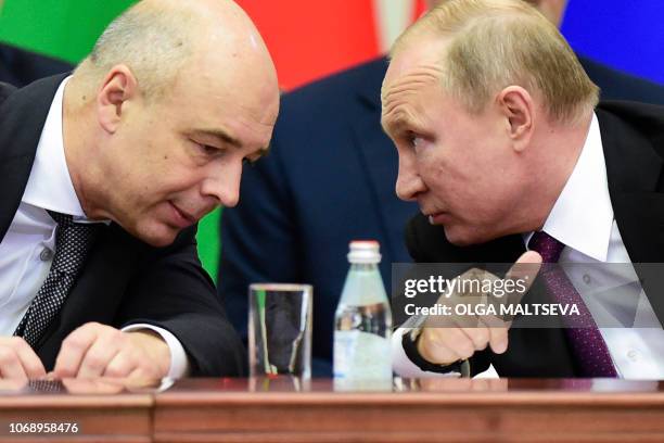 Russian President Vladimir Putin and Finance Minister Anton Siluanov chat during a meeting of the Supreme Eurasian Economic Council in Saint...