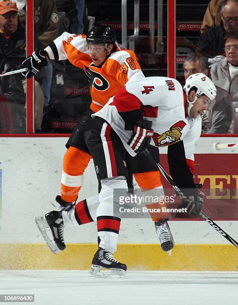 Chris Phillips of the Ottawa Senators hits Darroll Powe of the Philadelphia Flyers at the Wells Fargo Center on November 15, 2010 in Philadelphia,...