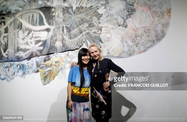 Japanese artist Maki Ohkojima poses with Frencg fashion designer Agnes Trouble aka Agnes B in front of her piece of art during the private view of...