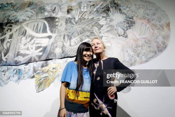 Japanese artist Maki Ohkojima poses with Frencg fashion designer Agnes Trouble aka Agnes B in front of her piece of art during the private view of...