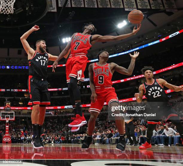 Justin Holiday of the Chicago Bulls rebounds over teammate Antonio Blakeney and Jonas Valanciunas and Malachi Richardson of the Toronto Raptors at...