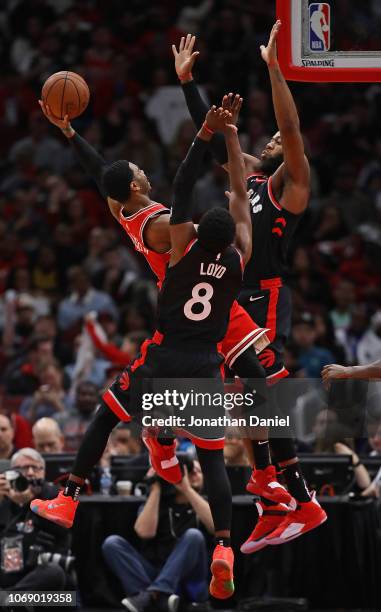 Shaquille Harrison of the Chicago Bulls puts up a shot against Greg Monroe and Jordan Loyd of the Toronto Raptors at United Center on November 17,...