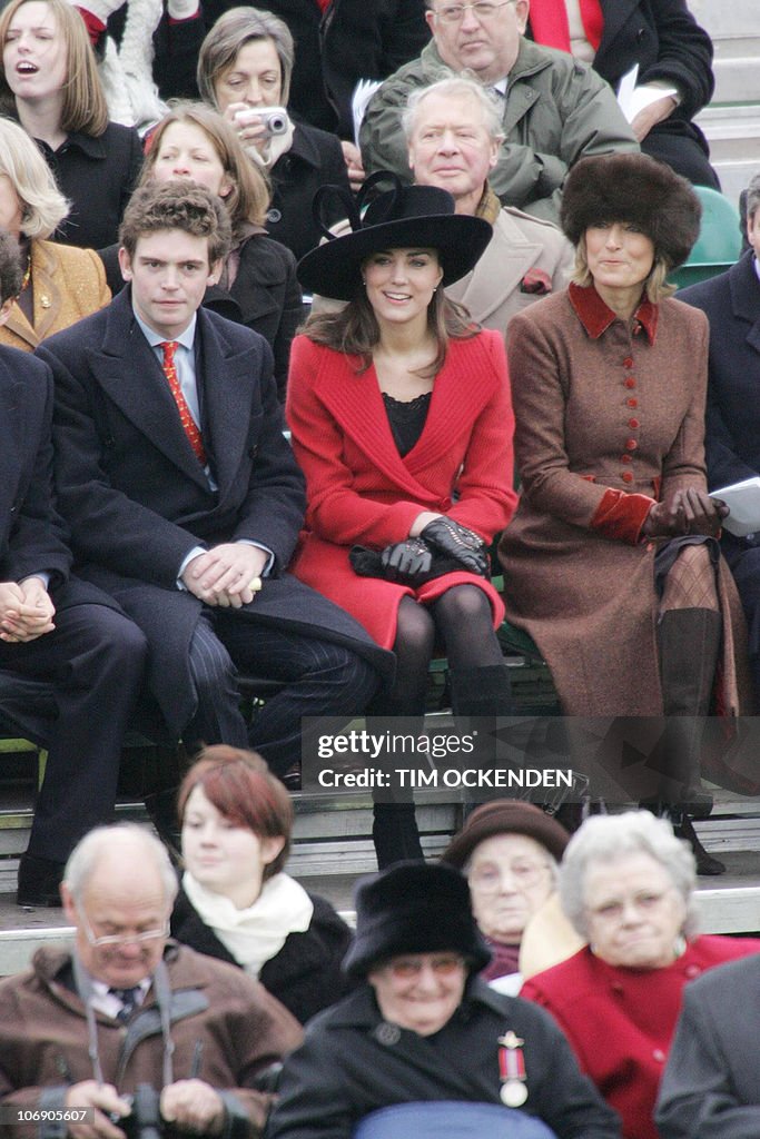 Kate Middleton, (red coat) sits in the s