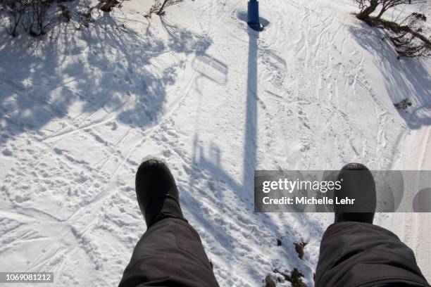 pov looking down to snowy ground from chairlift - winter skiing australia stock-fotos und bilder