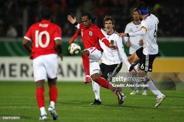 Nathan Delfouneso of England is challenged by Stefan Bell and Christoph Moritz of Germany during the U21 international friendly match between Germany...
