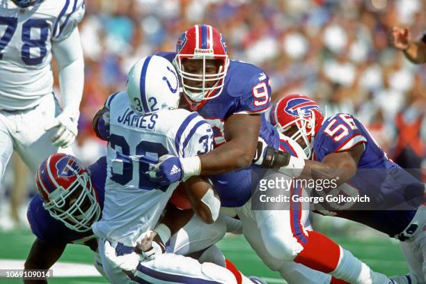 Defensive lineman Pat Williams of the Buffalo Bills tackles running back Edgerrin James of the Indianapolis Colts with assistance from defensive...