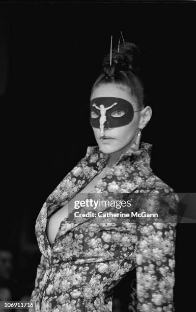 Model wearing a crucifix mask walks the runway at British fashion designer Alexander McQueen's first New York fashion show at a former synagogue on...