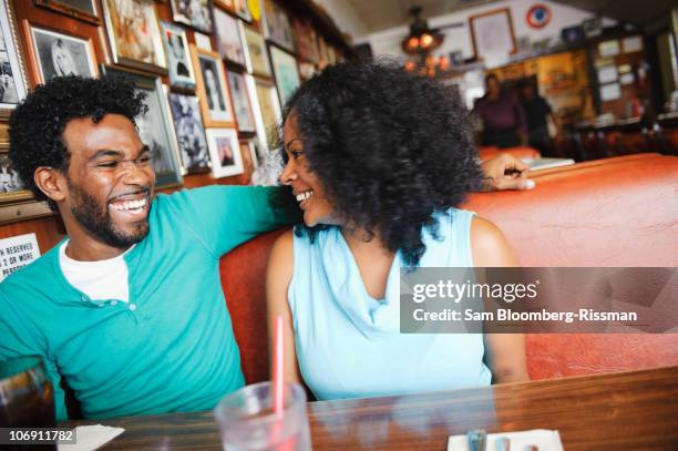 smiling couple sitting in diner booth - coppie cibo food bistrot foto e immagini stock