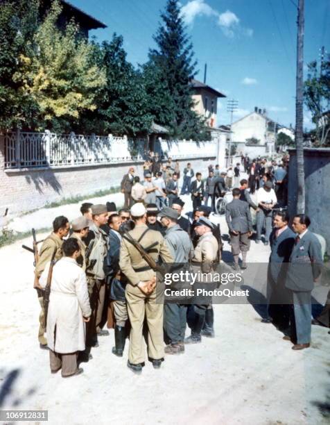 German commanders negotiate a surrender with several clergymen and assorted partisans on a residential street near Milan, Italy, May 1945.