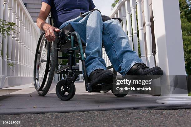 man with spinal cord injury in a wheelchair on the top of home access ramp - wheelchair ramp stock pictures, royalty-free photos & images