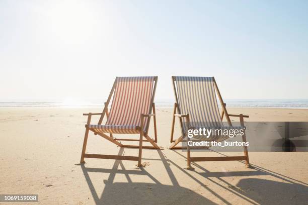 two deck chairs on beach - ligstoel stockfoto's en -beelden