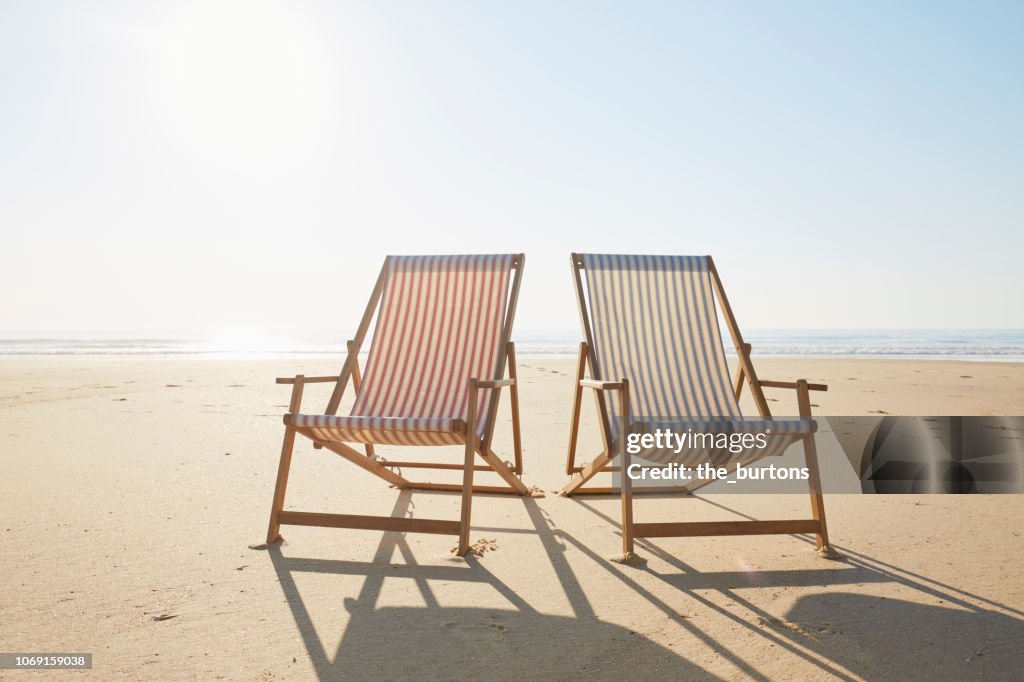 Two deck chairs on beach