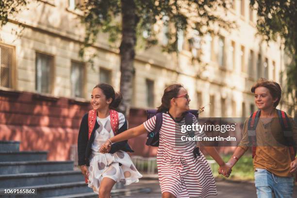 joyful school children running outside - leaving school imagens e fotografias de stock