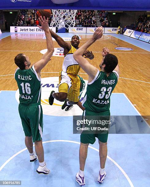 Louis Campbell, #13 of EWE Baskets Oldenburg in action with Slavko Vranes, #33 and Hasan Rizvic, #16 of Unics Kazan during the Eurocup Basketball...