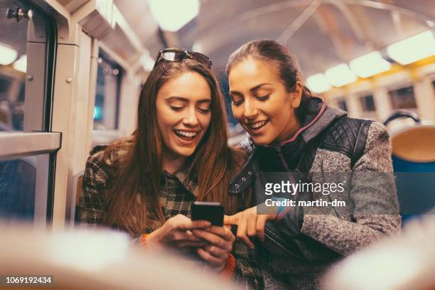 girls surfing social media in the subway train - cultura francesa imagens e fotografias de stock