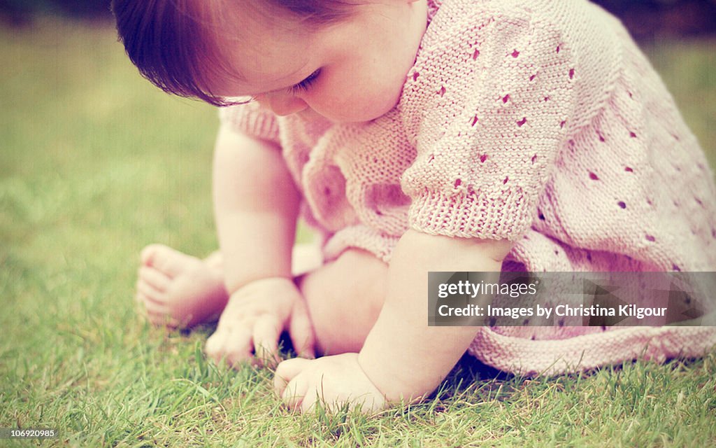 Baby girl sitting on grass