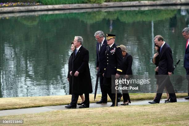 Former President George W. Bush and Laura Bush, along with Jeb and Columba Bush, Neil and Maria Bush and Marvin Bush, follow the flag-draped casket...