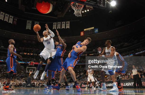 Carmelo Anthony of the Denver Nuggets puts up a shot over Amar'e Stoudemire and Danilo Gallinari of the New York Knicks at the Pepsi Center on...