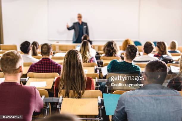 achteraanzicht van een grote groep studenten op een klasse op collegezaal. - universiteit stockfoto's en -beelden