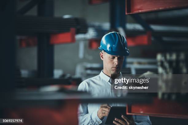 mid adult foreman working on digital tablet in aluminum mill. - quality control inspectors stock pictures, royalty-free photos & images