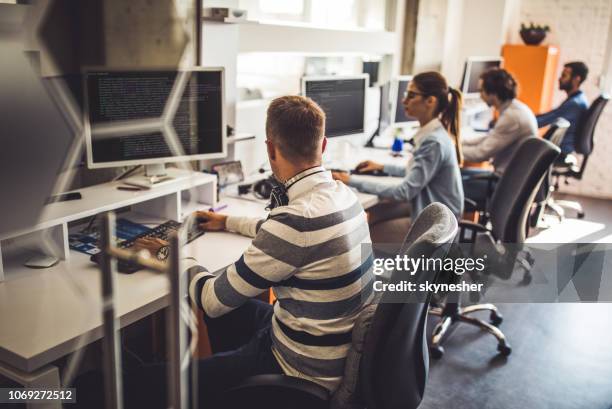 group of computer programmers working on pc's in the office. - online support stock pictures, royalty-free photos & images