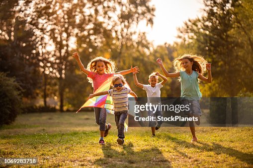 Group of happy children running in public park Group of happy children running in public park