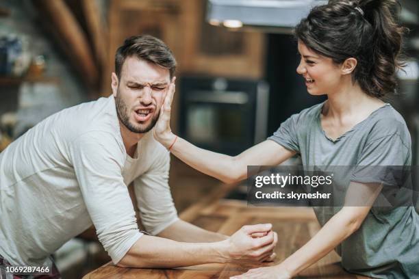 woman slapping her boyfriend for making a mistake at home. - slapping stock pictures, royalty-free photos & images