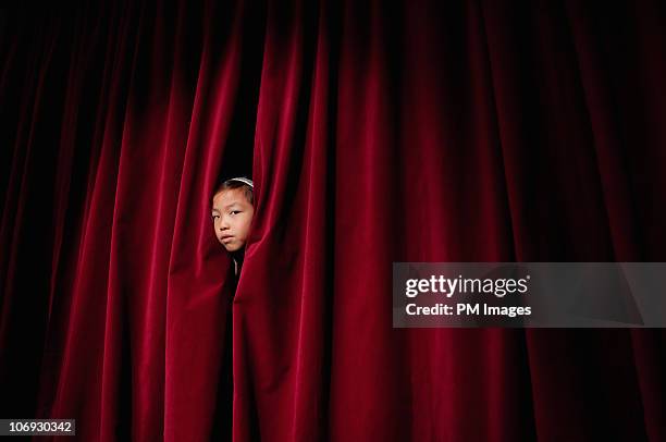 girl peeking through curtain - rideau de scène photos et images de collection