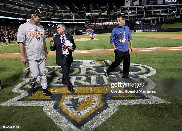 Baseball writer Tim Kurkjian talks with manager Bruce Bochy of the San Francisco Giants as Bochy walks off the field following their win against the...