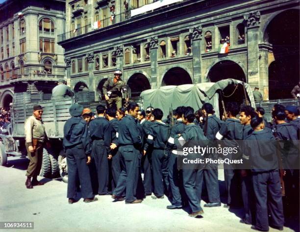 Italian partisans hands over their weapons to American MPs as they disband their units in front of the Palazzo dei Banchi in the Piazza Vittorio...