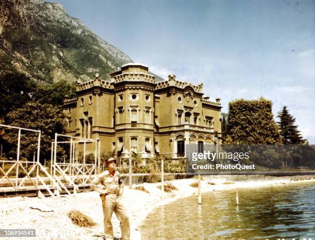 American MP Private First Class Verlin A. Larson, with 150th MP Company of the US 15th Army, stands at the water's edge in front of a villa named...