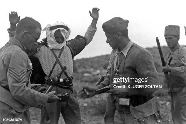 Picture dated 13 December 1938 shows Jewish settlement police members disarming an Arab marauder caught near Kibbutz Ramat David during the Arab...