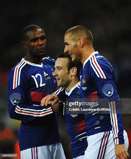 Mathieu Valbuena of France celebrates with Eric Abidal and Karim Benzema as he scores their second goal during the international friendly match...