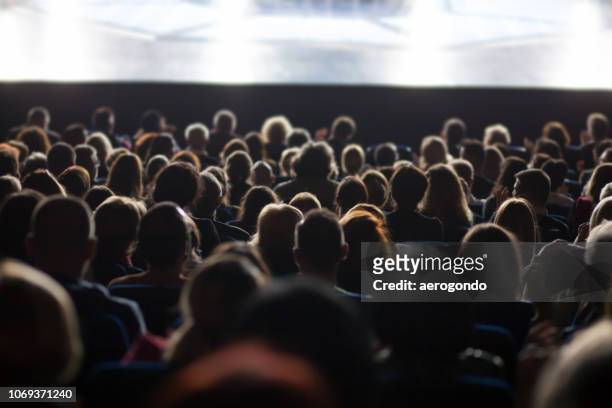 rear view of people sitting in auditorium during seminar - spectator stock pictures, royalty-free photos & images