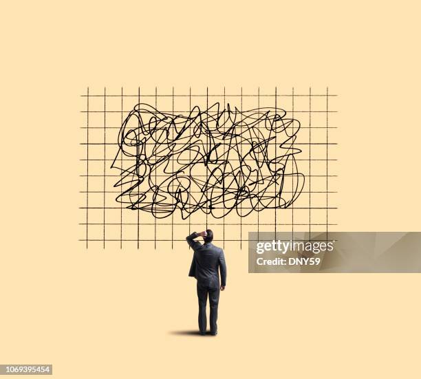 businessman looking up at chart showing unpredictable moves - uncertainty stock pictures, royalty-free photos & images