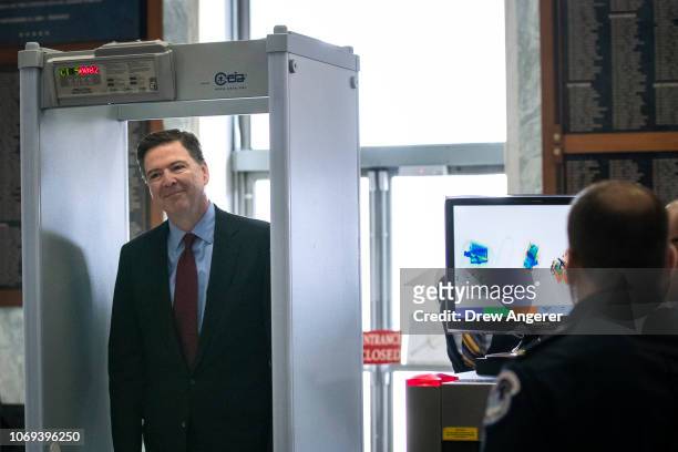 Former Federal Bureau of Investigation Director James Comey goes through security as he arrives at the Rayburn House Office Building before...