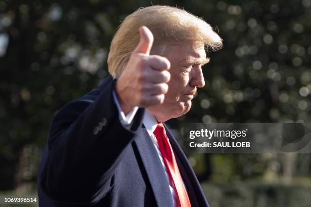 President Donald Trump gives a thumbs-up as he speaks to the press as he walks to Marine One prior to departing from the South Lawn of the White...